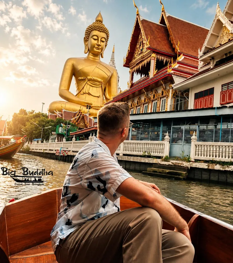 Private longtail boat on a narrow Bangkok canal with the five-colour Buddha stupa of Wat Paknam visible above the treeline